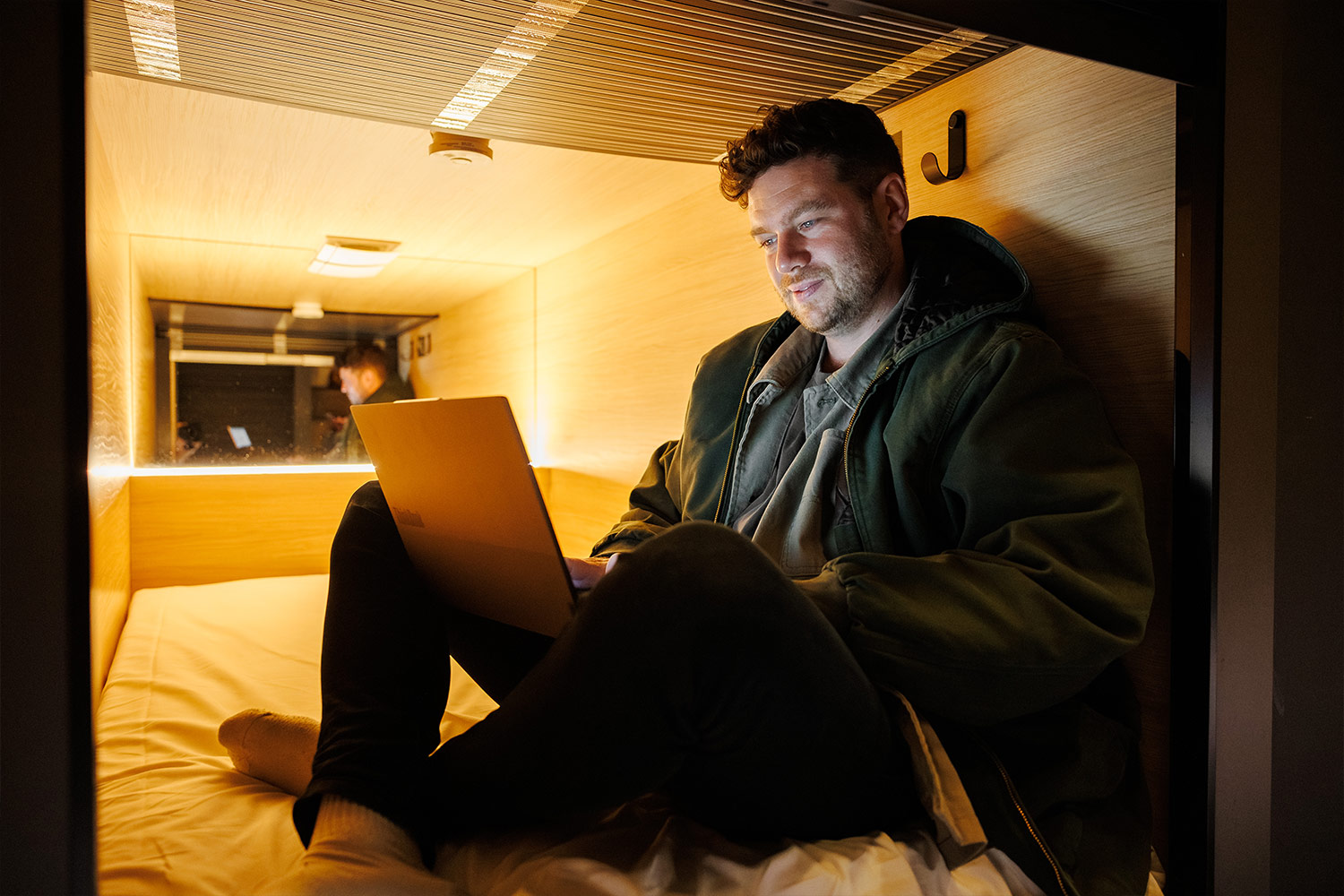 zedwell Hotels Capsule and man looking at his laptop